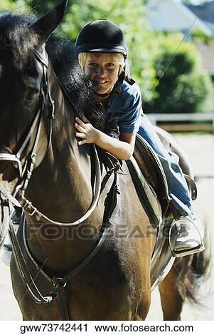 Portrait of a boy horseback riding View Large Photo Image Stock Image - Portrait of a boy horseback riding. Fotosearch