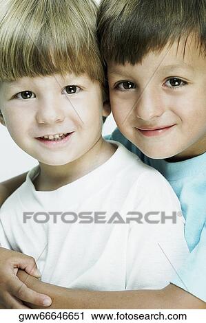 Stock Image - Portrait of a boy hugging his brother from behind. Fotosearch