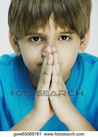 Stock Image - Portrait of a boy in a prayer position. Fotosearch