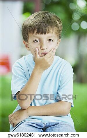 Stock Image - Portrait of a boy looking sad. Fotosearch