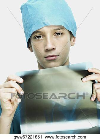 Portrait of a boy wearing surgical scrubs and showing an X-Ray View Large Photo Image Stock Image - Portrait of a boy wearing surgical scrubs and showing an X-Ray. Fotosearch