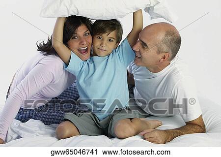 Portrait of a boy with his parents on the bed View Large Photo Image Stock Image - Portrait of a boy with his parents on the bed. Fotosearch