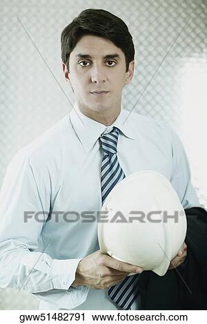 Portrait of a businessman holding a hardhat View Large Photo Image Stock Image - Portrait of a businessman holding a hardhat. Fotosearch
