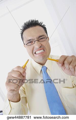 Portrait of a businessman holding broken pieces of a pencil View Large Photo Image Stock Image - Portrait of a businessman holding broken pieces of a pencil. Fotosearch
