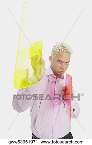 Stock Image - Portrait of a businessman holding two clipboards. Fotosearch