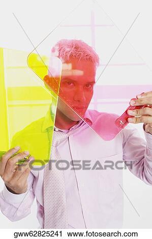 Stock Image - Portrait of a businessman holding two clipboards. Fotosearch