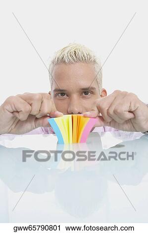 Stock Image - Portrait of a businessman playing with a notepad. Fotosearch
