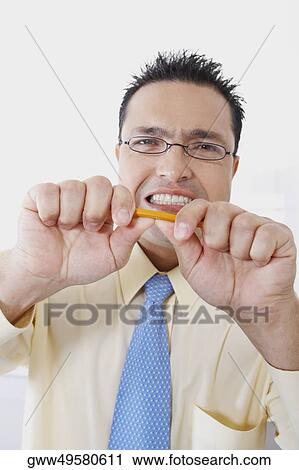 Portrait of a businessman trying to break a pencil View Large Photo Image Stock Image - Portrait of a businessman trying to break a pencil. Fotosearch