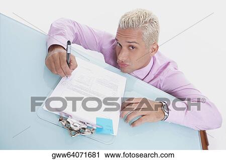 Portrait of a businessman writing on a sheet of paper and puckering his lips View Large Photo Image Stock Image - Portrait of a businessman writing on a sheet of paper and puckering his lips. Fotosearch