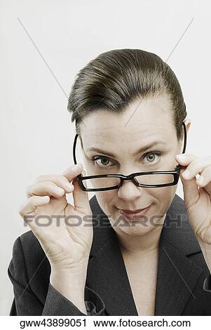 Portrait of a businesswoman adjusting her eyeglasses View Large Photo Image Stock Image - Portrait of a businesswoman adjusting her eyeglasses. Fotosearch
