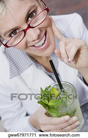 Portrait of a businesswoman holding a glass of mint julep and smiling View Large Photo Image Stock Image - Portrait of a businesswoman holding a glass of mint julep and smiling. Fotosearch