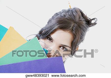 Portrait of a businesswoman holding files in front of her face View Large Photo Image Stock Image - Portrait of a businesswoman holding files in front of her face. Fotosearch