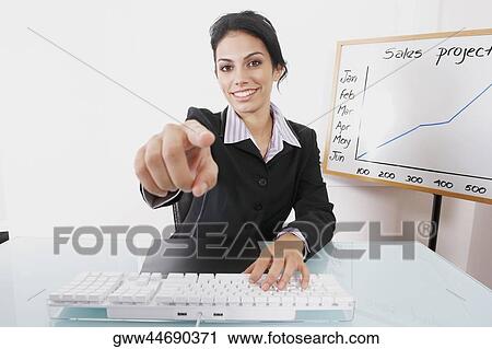 Portrait of a businesswoman pointing forward and smiling View Large Photo Image Stock Image - Portrait of a businesswoman pointing forward and smiling. Fotosearch