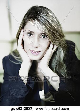 Stock Image - Portrait of a businesswoman with her hands on her chin. Fotosearch