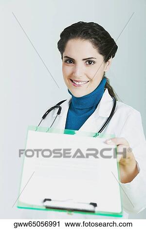 Portrait of a female doctor holding a clipboard and smiling View Large Photo Image Stock Image - Portrait of a female doctor holding a clipboard and smiling. Fotosearch