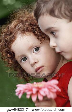 Portrait of a girl holding flower with a boy View Large Photo Image Stock Image - Portrait of a girl holding flower with a boy. Fotosearch