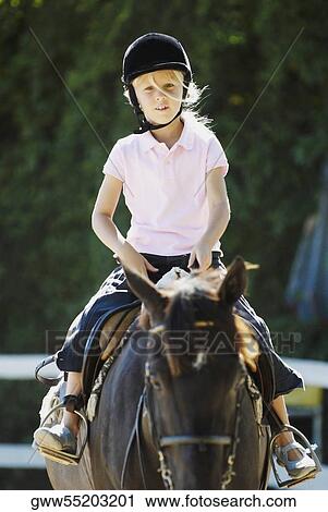 Stock Image - Portrait of a girl horseback riding. Fotosearch