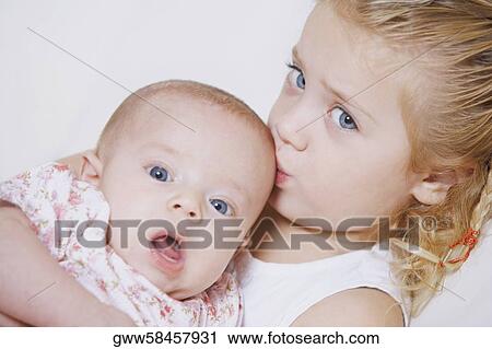 Portrait of a girl kissing her brother on his head View Large Photo Image Stock Image - Portrait of a girl kissing her brother on his head. Fotosearch