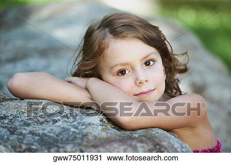 Portrait of a girl leaning on a rock View Large Photo Image Stock Image - Portrait of a girl leaning on a rock. Fotosearch