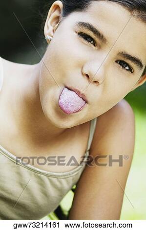 Stock Image - Portrait of a girl sticking her tongue out. Fotosearch