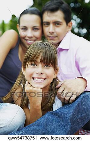 Portrait of a girl with her parents sitting and smiling View Large Photo Image Stock Image - Portrait of a girl with her parents sitting and smiling. Fotosearch