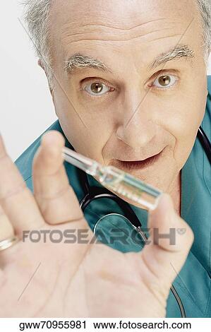 Portrait of a male doctor holding a vial View Large Photo Image Stock Image - Portrait of a male doctor holding a vial. Fotosearch