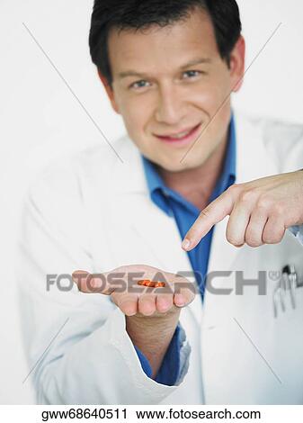 Portrait of a male doctor showing pills on his palm View Large Photo Image Stock Image - Portrait of a male doctor showing pills on his palm. Fotosearch