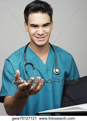 Portrait of a male surgeon holding a medical report and smiling View Large Photo Image Stock Image - Portrait of a male surgeon holding a medical report and smiling. Fotosearch