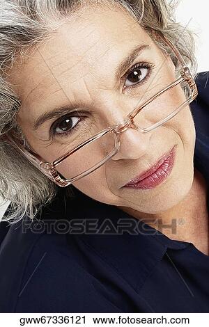 Portrait of a mature woman peeking over eyeglasses View Large Photo Image Stock Image - Portrait of a mature woman peeking over eyeglasses. Fotosearch