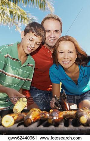 Portrait of a mid adult couple with their son in front of a barbecue grill View Large Photo Image Stock Image - Portrait of a mid adult couple with their son in front of a barbecue grill. Fotosearch