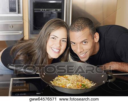 Portrait of a mid adult man and a young woman looking from behind a kitchen counter View Large Photo Image Stock Image - Portrait of a mid adult man and a young woman looking from behind a kitchen counter. Fotosearch