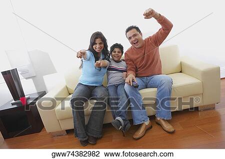 Portrait of a mid adult man and a young woman sitting with their son on a couch and smiling View Large Photo Image Stock Image - Portrait of a mid adult man and a young woman sitting with their son on a couch and smiling. Fotosearch