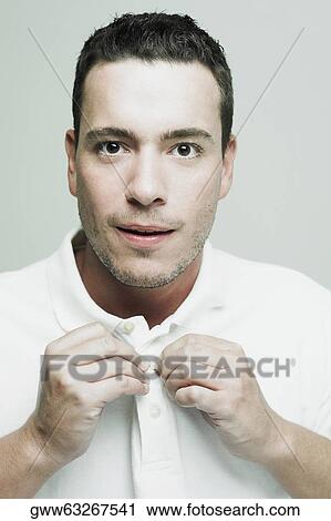 Portrait of a mid adult man buttoning his polo shirt View Large Photo Image Stock Image - Portrait of a mid adult man buttoning his polo shirt. Fotosearch