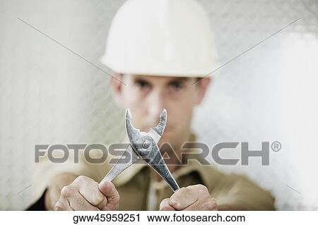 Portrait of a mid adult man holding a pair of pliers View Large Photo Image Stock Image - Portrait of a mid adult man holding a pair of pliers. Fotosearch