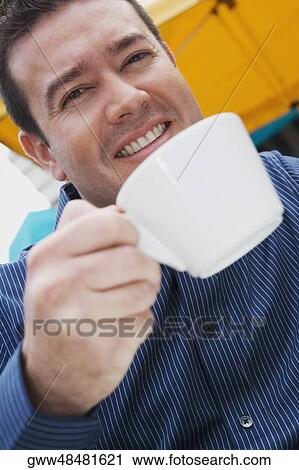 Portrait of a mid adult man holding a cup of tea View Large Photo Image Stock Image - Portrait of a mid adult man holding a cup of tea. Fotosearch