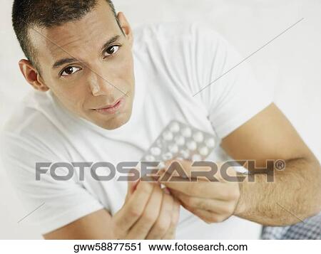 Portrait of a mid adult man holding a pill and a blister pack View Large Photo Image Stock Image - Portrait of a mid adult man holding a pill and a blister pack. Fotosearch