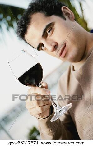 Portrait of a mid adult man holding a glass of red wine View Large Photo Image Stock Image - Portrait of a mid adult man holding a glass of red wine. Fotosearch