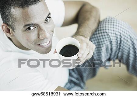 Portrait of a mid adult man holding a cup of black tea and smiling View Large Photo Image Stock Image - Portrait of a mid adult man holding a cup of black tea and smiling. Fotosearch