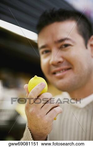 Portrait of a mid adult man holding a lemon View Large Photo Image Stock Image - Portrait of a mid adult man holding a lemon. Fotosearch