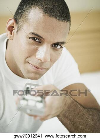 Portrait of a mid adult man holding a remote control View Large Photo Image Stock Image - Portrait of a mid adult man holding a remote control. Fotosearch