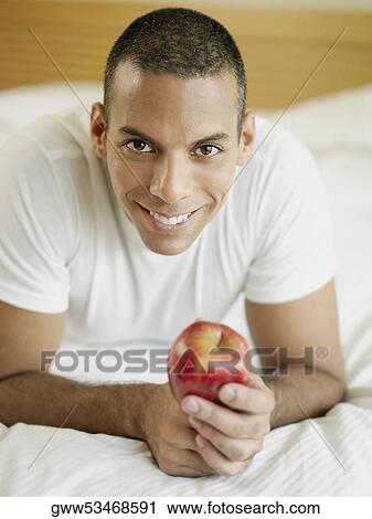 Portrait of a mid adult man holding an apple and smiling View Large Photo Image Stock Image - Portrait of a mid adult man holding an apple and smiling. Fotosearch