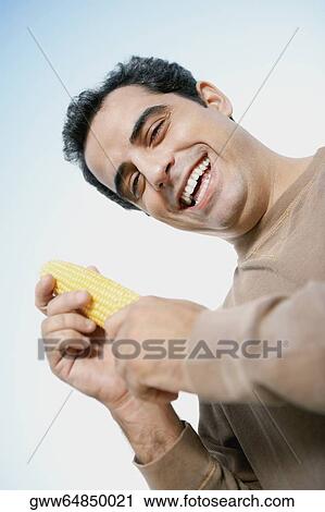 Portrait of a mid adult man holding corn View Large Photo Image Stock Image - Portrait of a mid adult man holding corn. Fotosearch