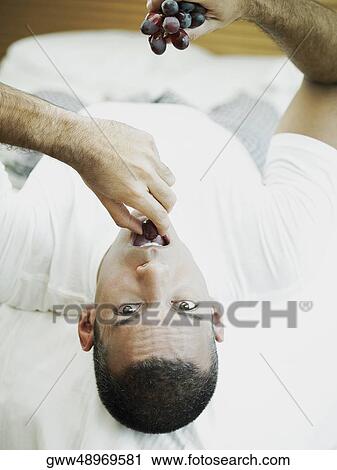 Portrait of a mid adult man holding red grapes View Large Photo Image Stock Image - Portrait of a mid adult man holding red grapes. Fotosearch