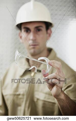 Portrait of a mid adult man holding protective eyewear View Large Photo Image Stock Image - Portrait of a mid adult man holding protective eyewear. Fotosearch