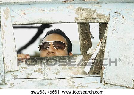 Portrait of a mid adult man looking through a wooden wall View Large Photo Image Stock Image - Portrait of a mid adult man looking through a wooden wall. Fotosearch