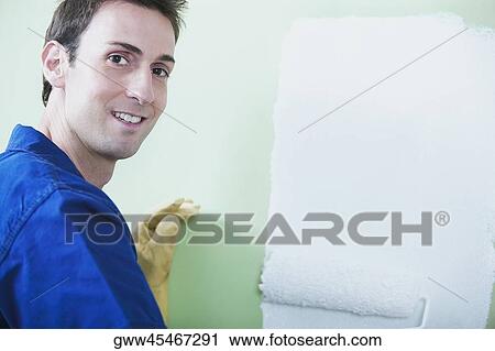 Portrait of a mid adult man painting a wall with a paint roller View Large Photo Image Stock Image - Portrait of a mid adult man painting a wall with a paint roller. Fotosearch