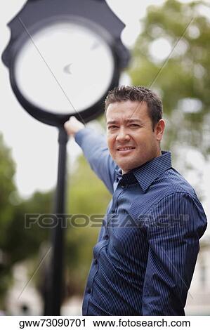 Portrait of a mid adult man pointing towards a watch View Large Photo Image Stock Image - Portrait of a mid adult man pointing towards a watch. Fotosearch