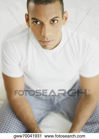 Portrait of a mid adult man sitting on the bed View Large Photo Image Stock Image - Portrait of a mid adult man sitting on the bed. Fotosearch