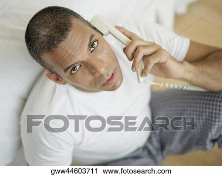 Stock Image - Portrait of a mid adult man talking on the telephone. Fotosearch