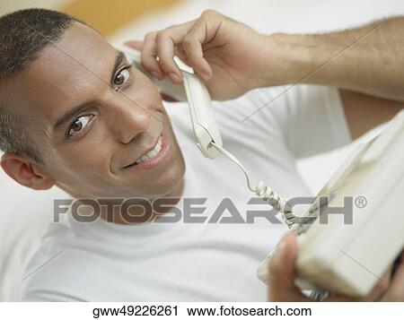 Portrait of a mid adult man talking on the telephone and smiling View Large Photo Image Stock Image - Portrait of a mid adult man talking on the telephone and smiling. Fotosearch